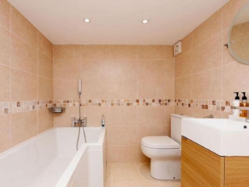 a bathroom with a tub and a toilet and a sink at Harbour View in Kingswear