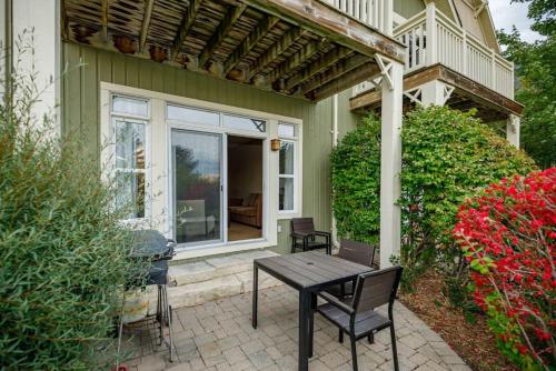 a patio with a table and chairs in front of a house at Blue Mountain Retreat at Rivergrass in Blue Mountains