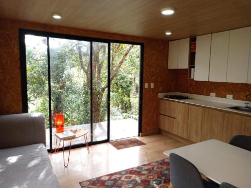 una cocina con una gran ventana de cristal y una mesa en Refugio de la Montaña en el Alto del Escobero en El Retiro