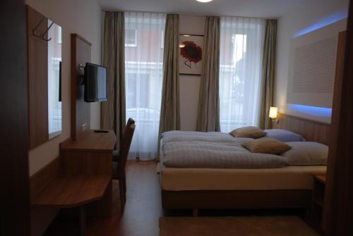 ein Hotelzimmer mit 2 Betten und einem TV in der Unterkunft Hotel Rest Inn in Bretten