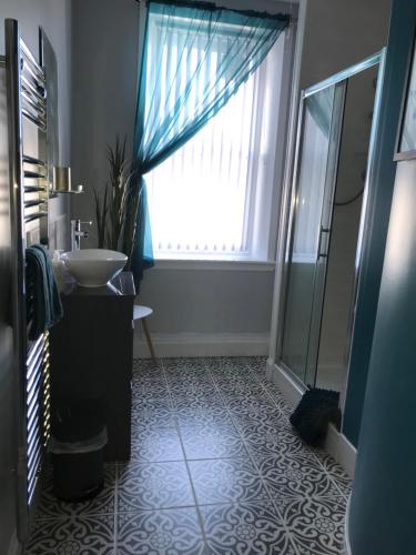 a bathroom with a sink and a window at Curlew Cottage and Sunset View in Port Logan
