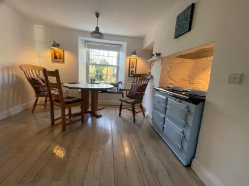 a kitchen with a table and chairs in a room at May House A beautiful Cornish holiday home in the heart of Cornwall in Wadebridge