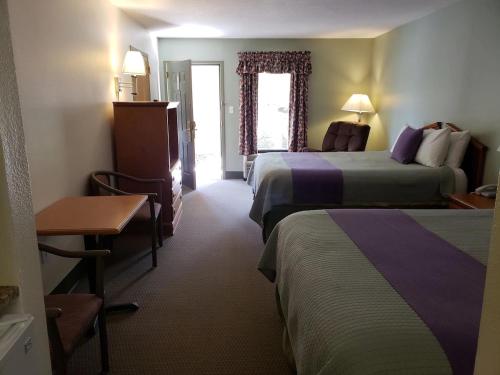 a hotel room with two beds and a table at Hot Springs Village Inn in Hot Springs Village