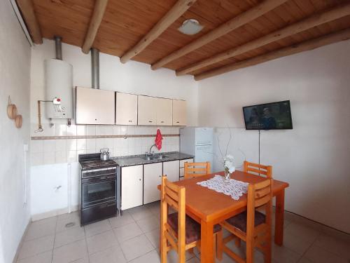 y cocina con mesa, sillas y fogones. en Departamento Elida, en San Rafael