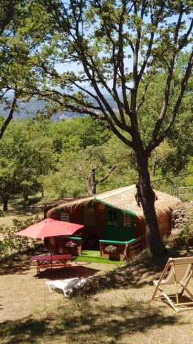 a hut with a picnic table and a tree at La lyalis in Aiguines