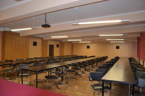an empty lecture room with tables and chairs at Hotel Skaut in Chorzów