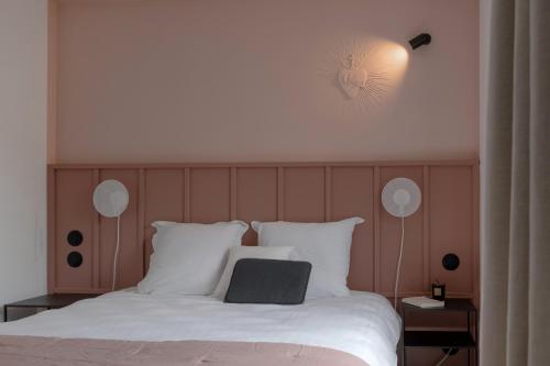 a bedroom with a bed with a black laptop on it at Hôtel Le Prieuré in Paray-le-Monial