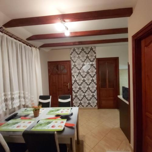 a dining room with a table and chairs in a room at Melinda nyaralóház in Balatonkenese