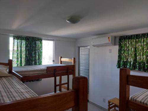 um quarto com 2 beliches e uma janela em Casarão Nazaré Hostel em Salvador