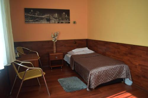 a bedroom with a bed and a table and chairs at Hotel Skaut in Chorzów