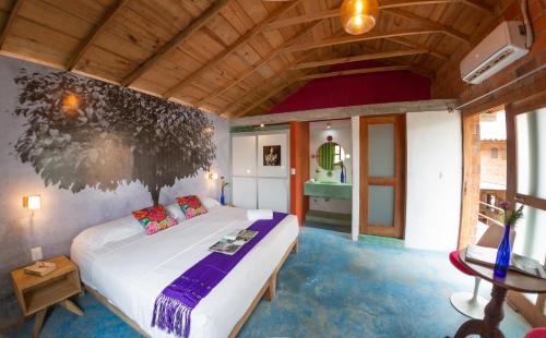 a bedroom with a white bed and a wooden ceiling at Hotel Pochote Mazunte in Mazunte