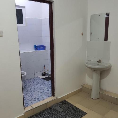 ein Badezimmer mit Toilette und Waschbecken in der Unterkunft Joy BNB in Mombasa