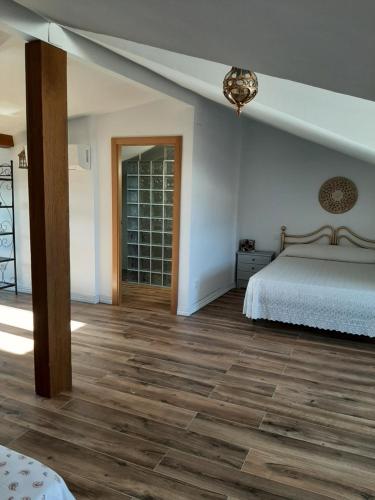 a bedroom with a bed and a wooden floor at Horizontes de La Mancha in El Toboso