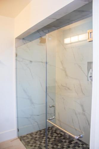 a shower with a glass door in a bathroom at Casa Amaroo - Villa at Luna Beach Roatan in Roatan