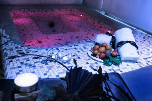 a swimming pool with a plate of fruit on a table at UNAHOTELS Villa dei Platani Foligno in Foligno