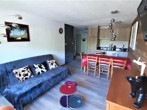 un salon avec un canapé bleu et une cuisine dans l'établissement Appartement cosy 8 pers. à La Clusaz, proche piscine et centre, idéal familles. - FR-1-459-14, à La Clusaz