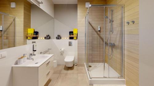 a bathroom with a shower and a toilet and a sink at SGIGOLF Apartments No3 No2 in Wejherowo