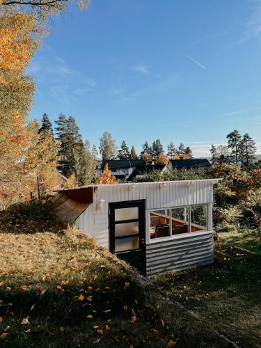a small white shed sitting on top of a hill at Charming house with wood stove near lake in Virserum