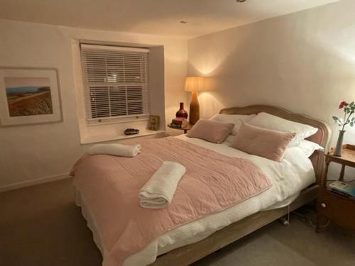 a bedroom with a large bed and a window at May House A beautiful Cornish holiday home in the heart of Cornwall in Wadebridge