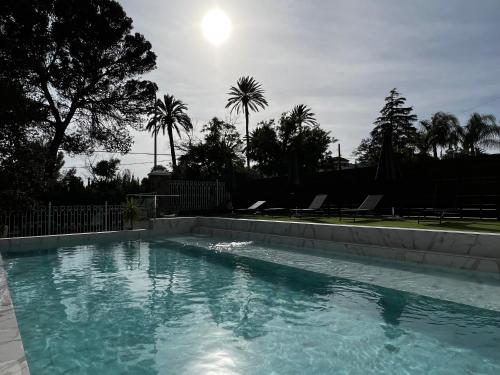 a swimming pool with the sun in the background at Los Almendros - Free Parking in Córdoba