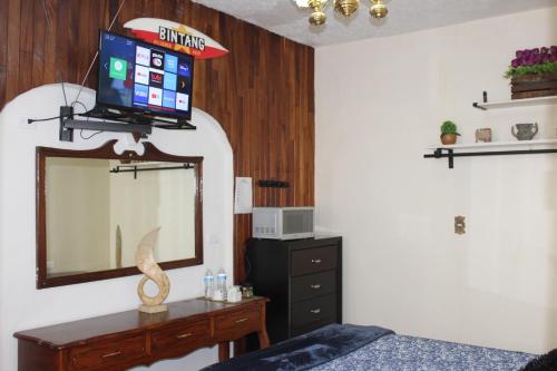 a bedroom with a mirror and a dresser and a tv at Habitacion 2 acceso independiente y autonomo Puebla in Puebla