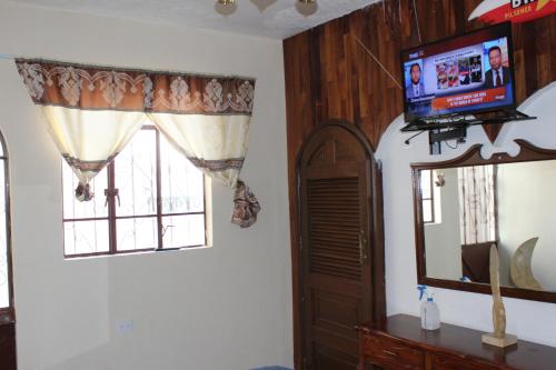 a living room with a television and a window at Habitacion 2 acceso independiente y autonomo Puebla in Puebla