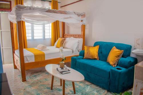 a living room with a bed and a blue couch at Urban studios in Kilifi