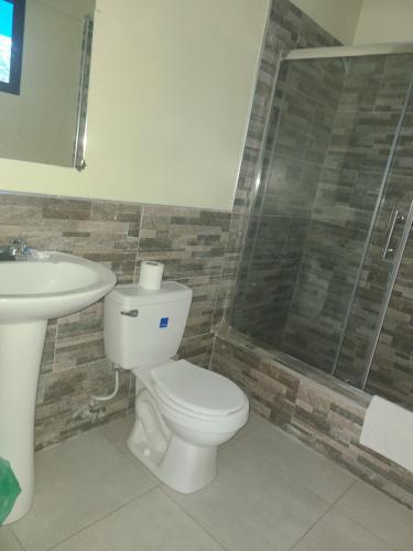 a bathroom with a toilet and a sink and a shower at Tamboo Resort in Negril