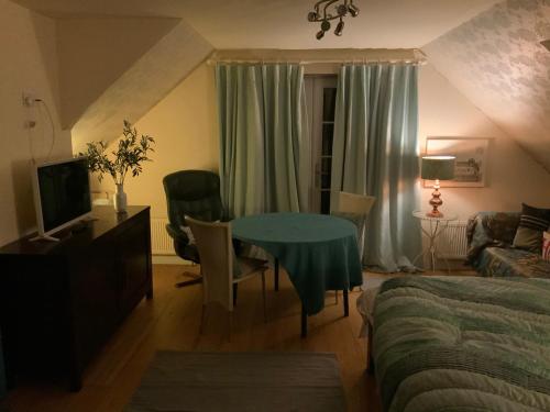 een woonkamer met een blauwe tafel en een bed bij Hurstbourne in Camberley