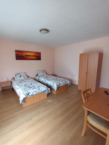 a room with two beds and a table in it at Guest rooms Bansko in Bansko