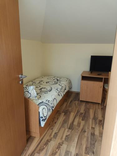 a small bedroom with a bed and a desk at Guest rooms Bansko in Bansko