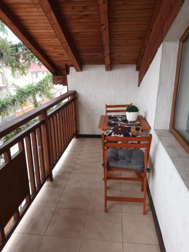 a balcony with a wooden table and a chair at Guest rooms Bansko in Bansko