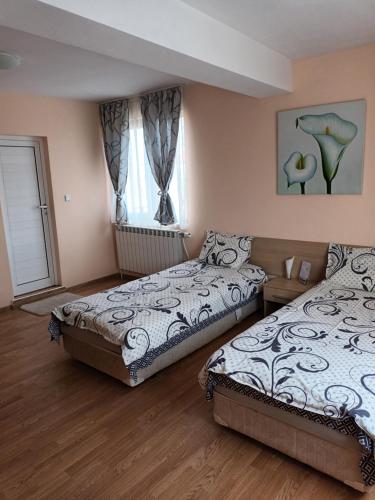 a bedroom with two beds and a window at Guest rooms Bansko in Bansko