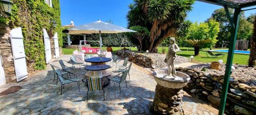 um pátio com uma mesa, cadeiras e um guarda-sol em La Casalamadonna em Santa-Lucia-di-Moriani