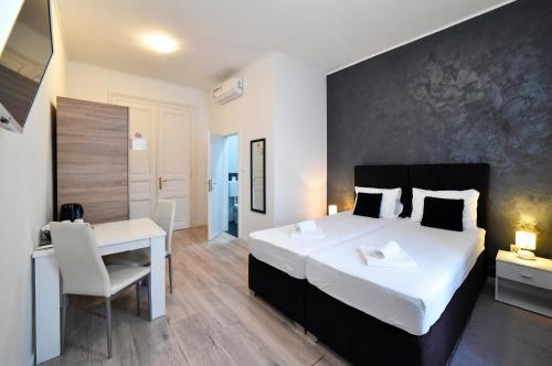 a bedroom with a large white bed and a desk at Virtus Apartments and Rooms with Free Private Parking in Zagreb