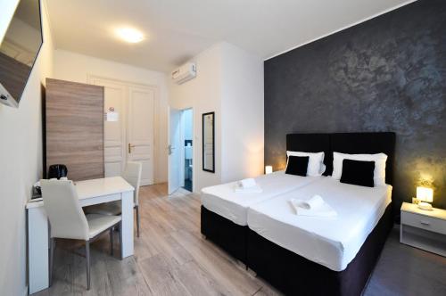 - une chambre avec un grand lit blanc et un bureau dans l'établissement Virtus Apartments and Rooms with Free Private Parking, à Zagreb