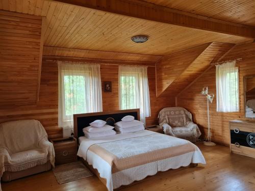 スキュネイザにあるPryvitannya Sontsyuのベッドルーム1室(ベッド1台、椅子2脚付)
