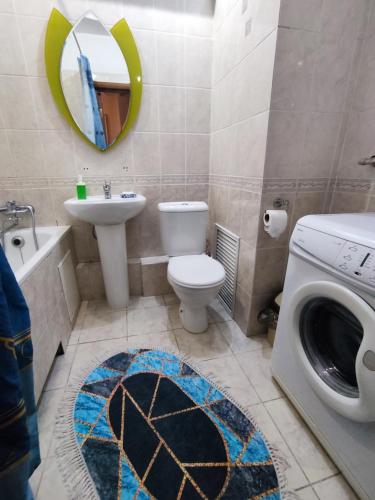 a bathroom with a toilet sink and a washing machine at X,ata in Almaty