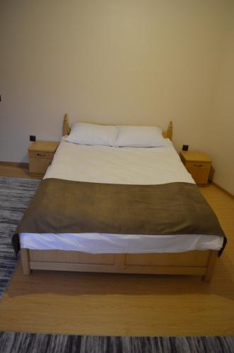 a neatly made bed in a small room at Transilvania Garden House in Miercurea-Ciuc