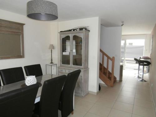 une salle à manger avec une table, des chaises et une armoire dans l'établissement LesOnagres1, au Crotoy