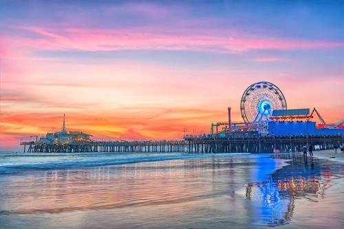 a pier with a ferris wheel on the beach at sunset at Super-Cute 2/2 apartment in Santa Monica with free parking in Los Angeles