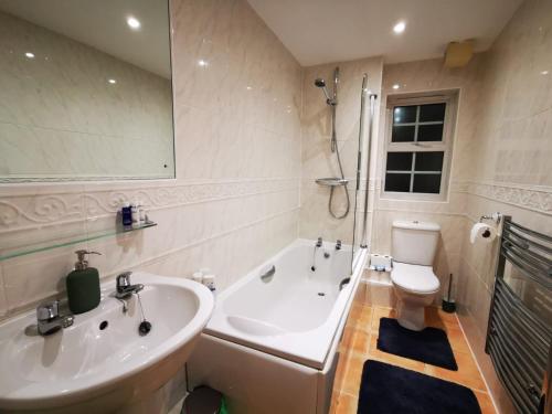 a bathroom with a tub and a sink and a toilet at Gorgeous apartment + attentive host + free parking in York
