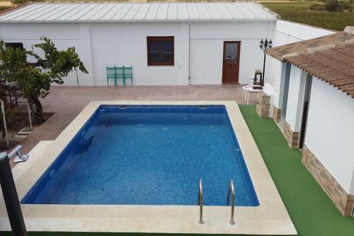 a swimming pool in front of a house at Casa Rural Horizontes de la Mancha in El Toboso