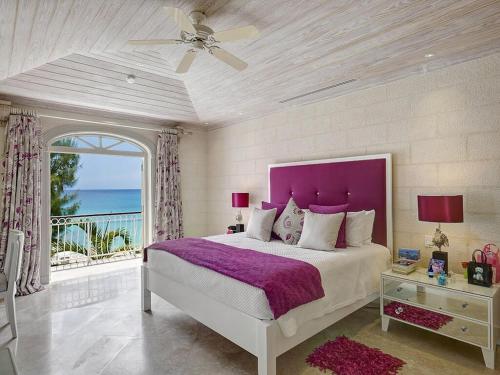 a bedroom with a large bed with a purple headboard at Firefly at Old Trees in Saint James