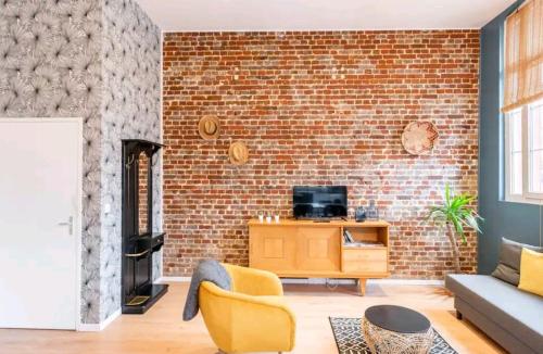 a living room with a brick wall at 4 Spacieux, chaleureux, hyper centre 300m de la mer in Dieppe