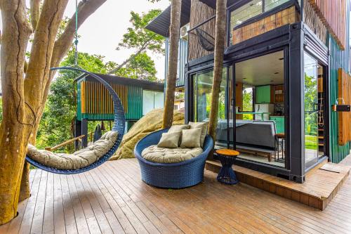 a house with two swinging chairs on a deck at Casa Natu Ilhabela Portinho in Ilhabela