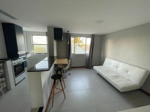 uma sala de estar com um sofá e uma cozinha em Apartamento Lagoa de Saquarema em Saquarema