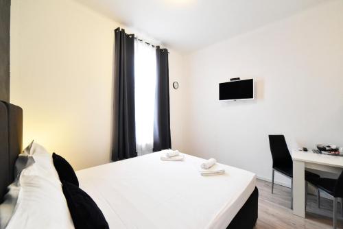 a room with a bed and a desk and a television at Virtus Apartments and Rooms with Free Private Parking in Zagreb