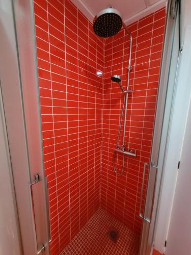een rode betegelde douche met een douchekop in de badkamer bij Holidays near the beach in Alicante