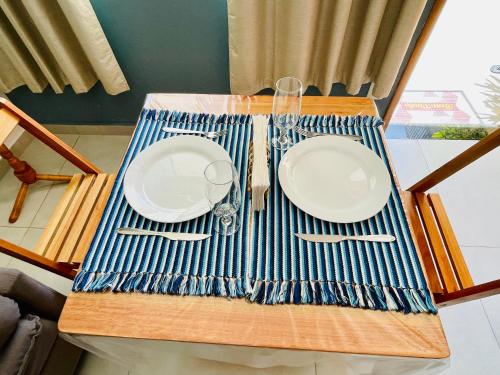 a table with white plates and silverware on it at Morada do Mar Arraial do Cabo in Arraial do Cabo